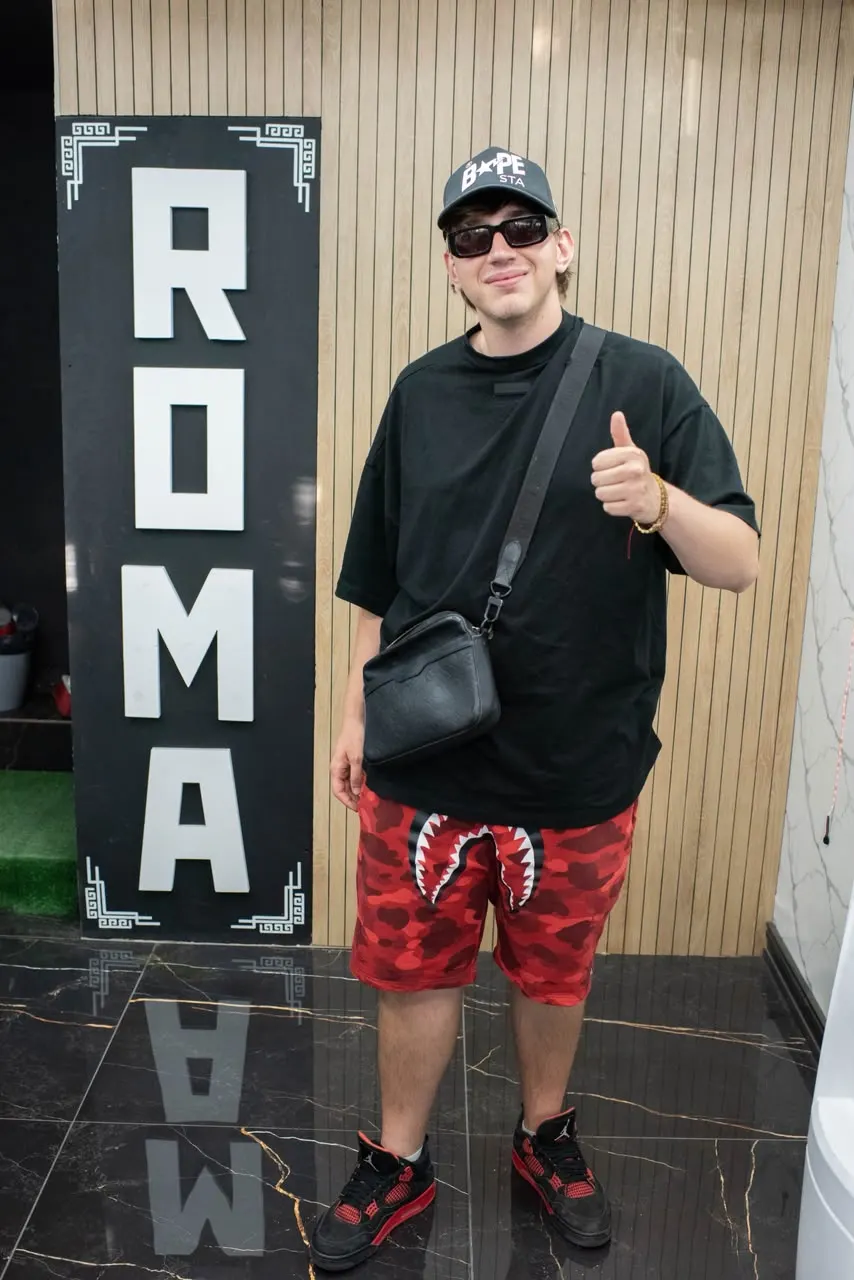 Un invitado junto al cartel de ROMA