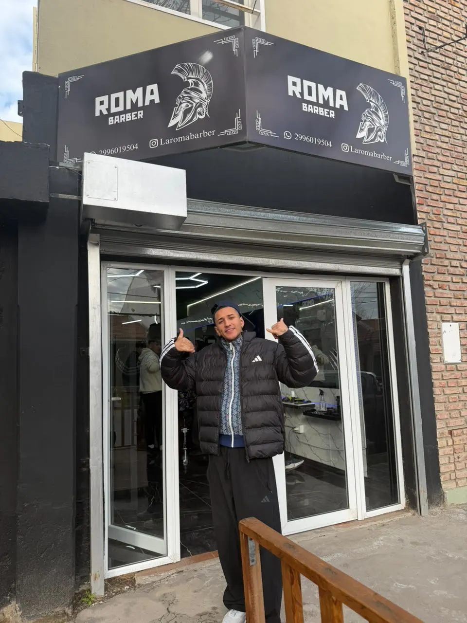 La entrada del local con el cartel de ROMA Barber
